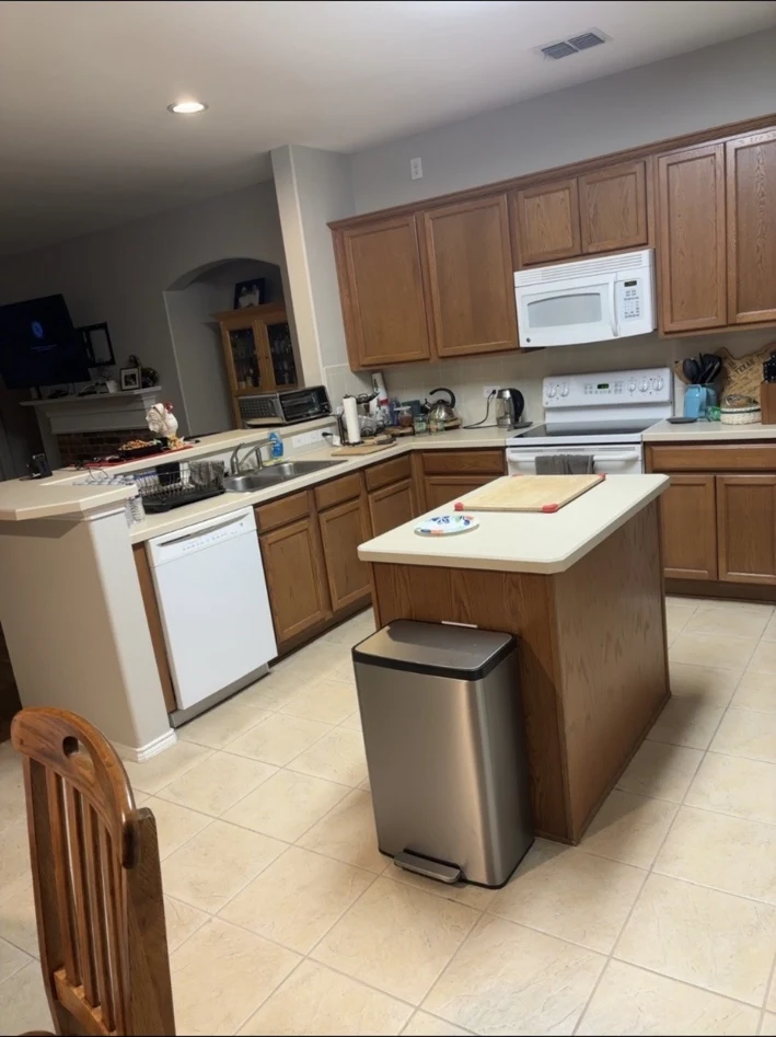 Kitchen before remodeling, with wood cabinets and an older island